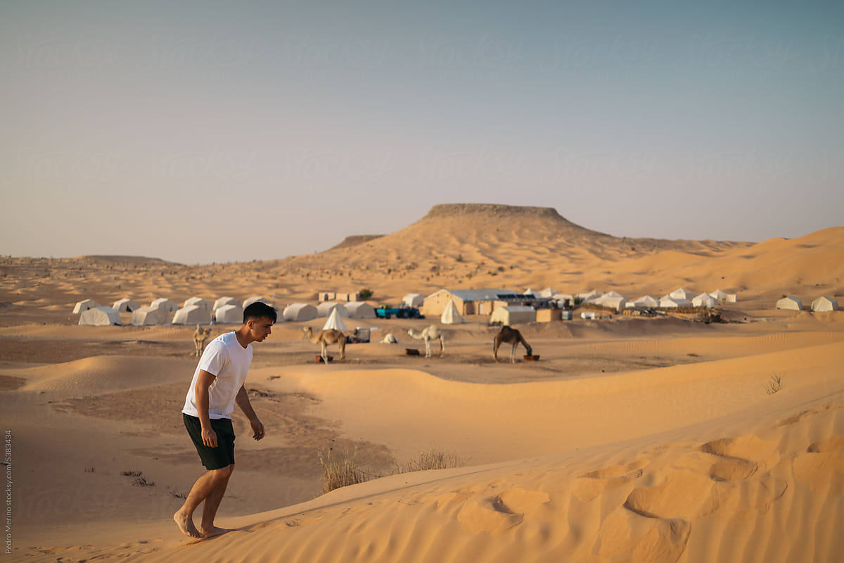 Young traveler man in a tent camp in the Sahara desert