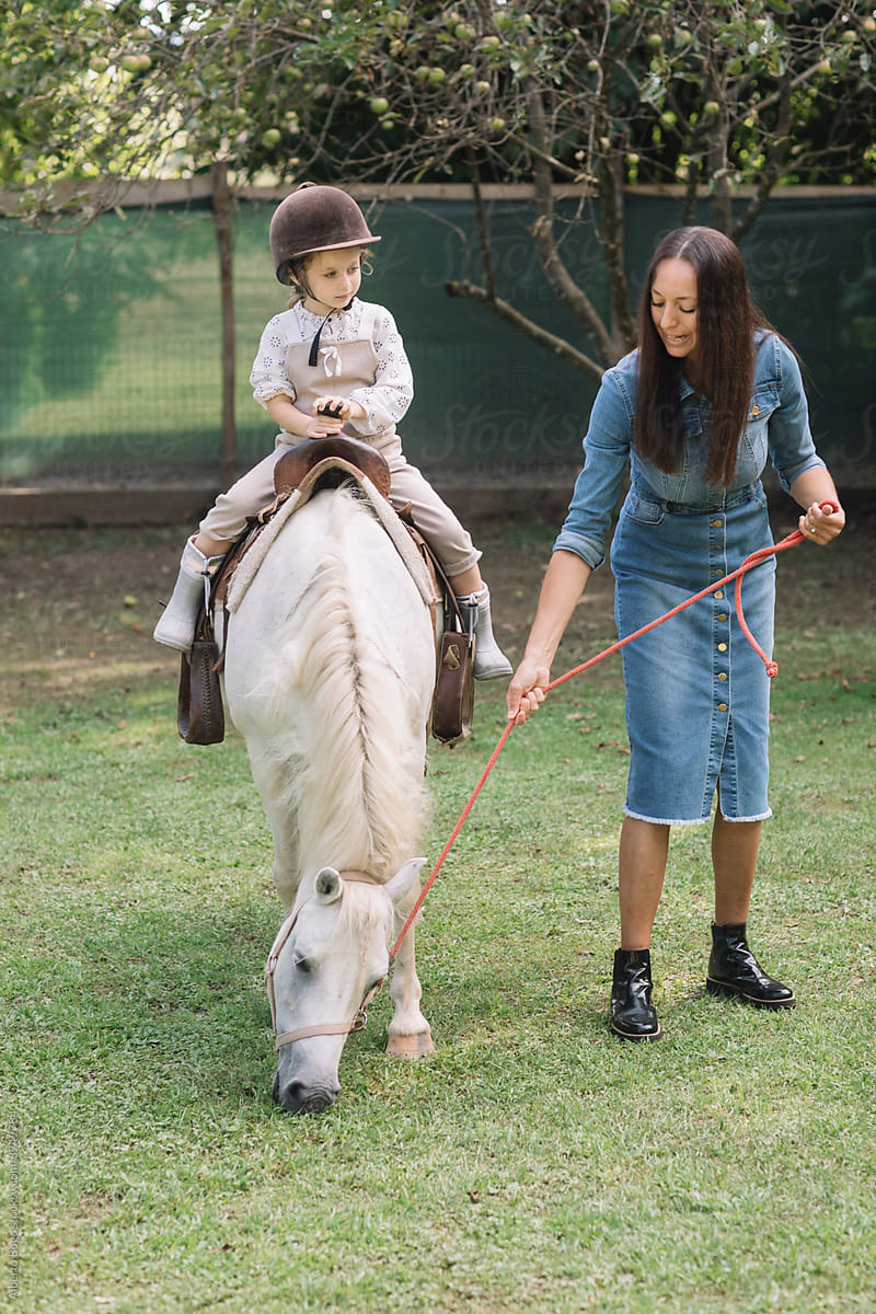 Litttle Girl Riding A Horse At Farm