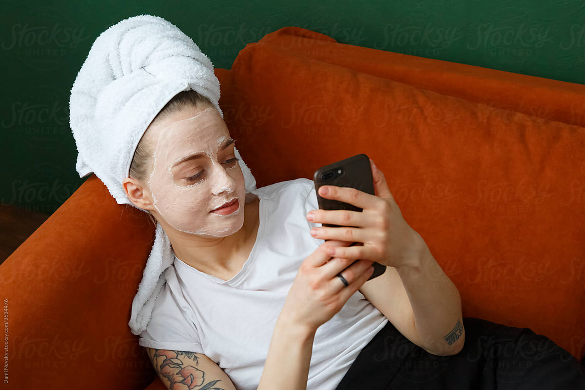 Young woman with mask using smartphone