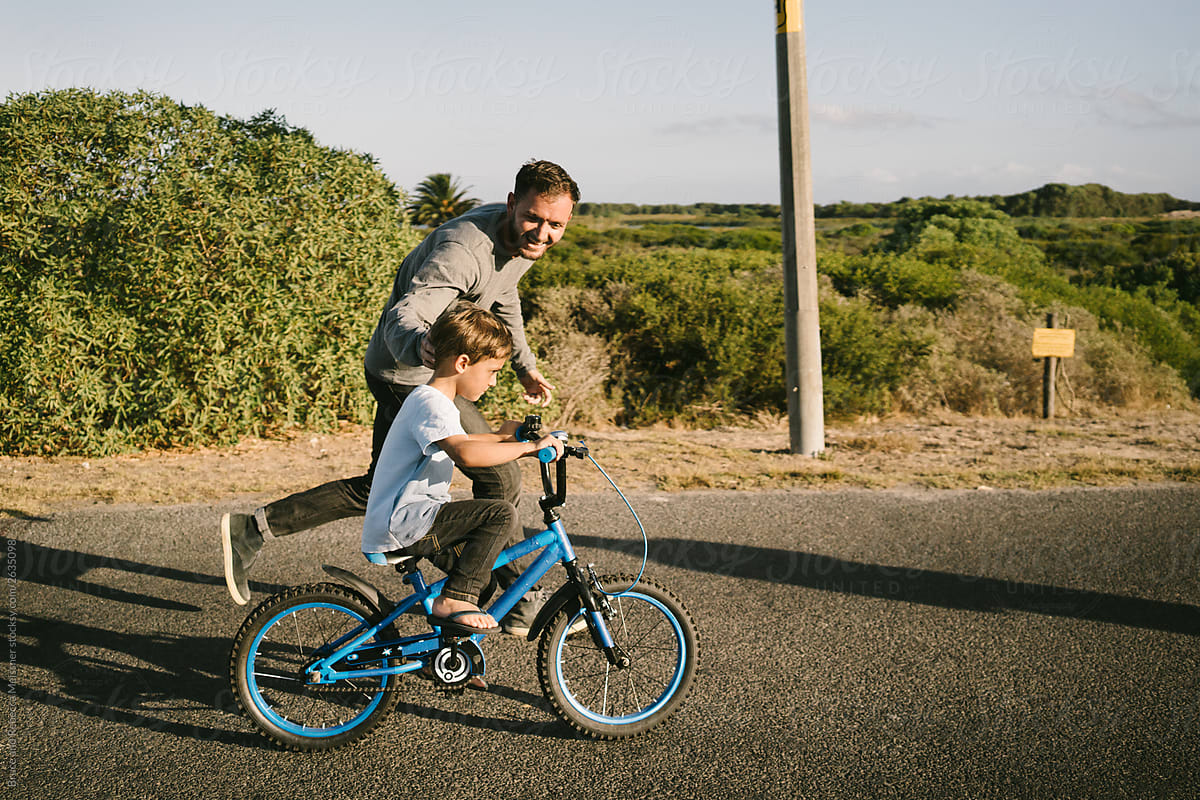 Dad teaching son to ride a bike