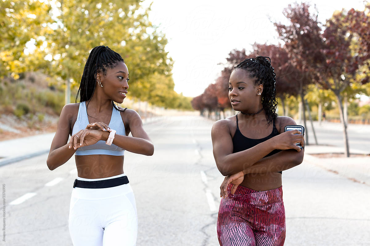 Two women friends chatting outdoors on sportswear