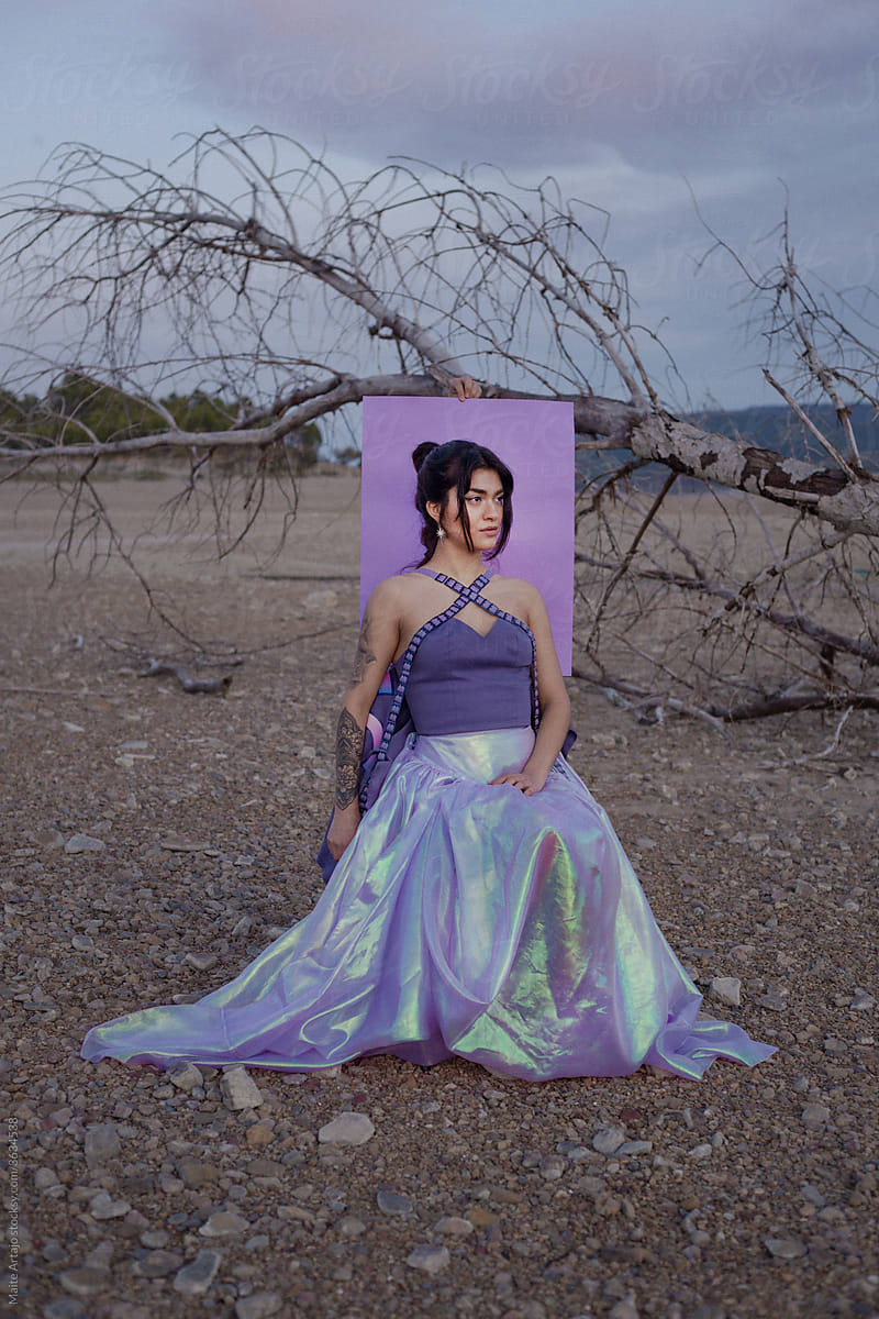 Woman with purple dress in front of a tree