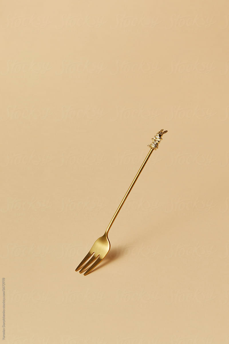 One small golden fork with rabbit on the handle