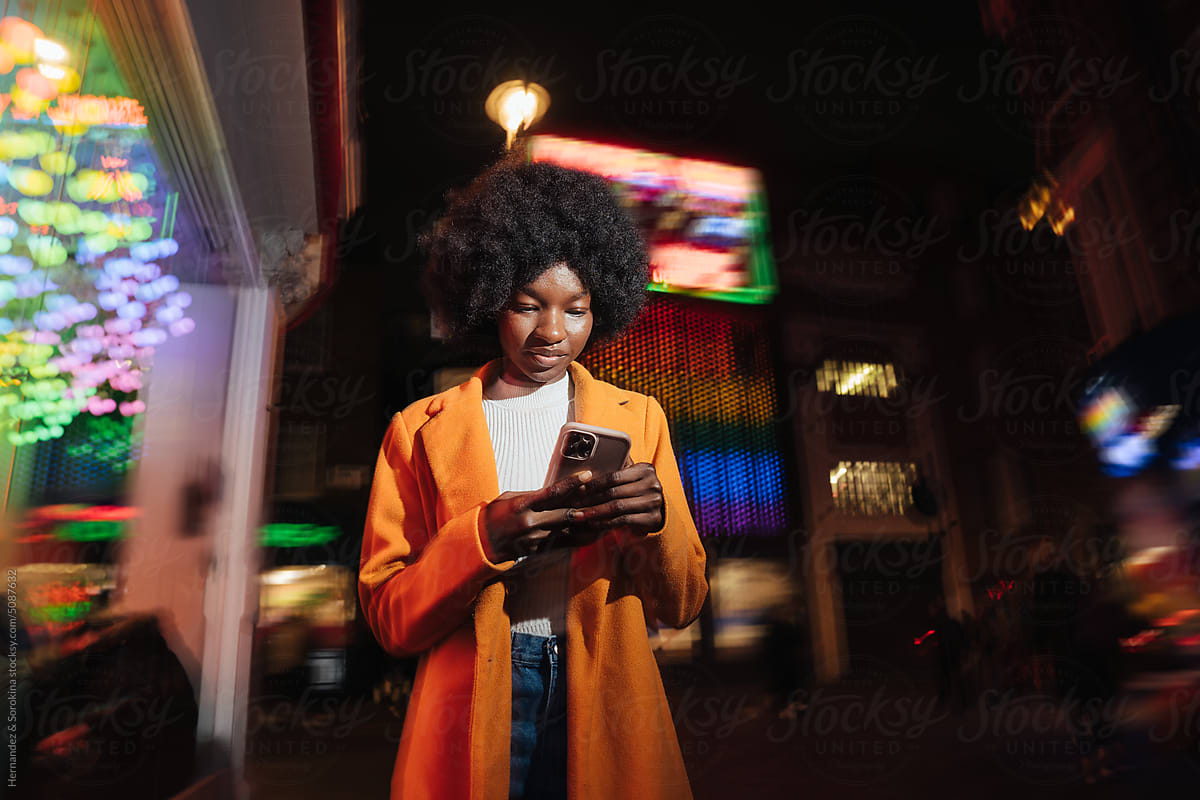 Woman Using Phone On The Street At Night