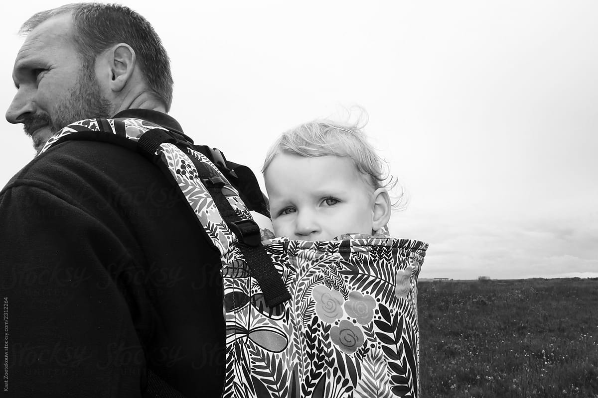 Black and white shot of toddler in baby carrier