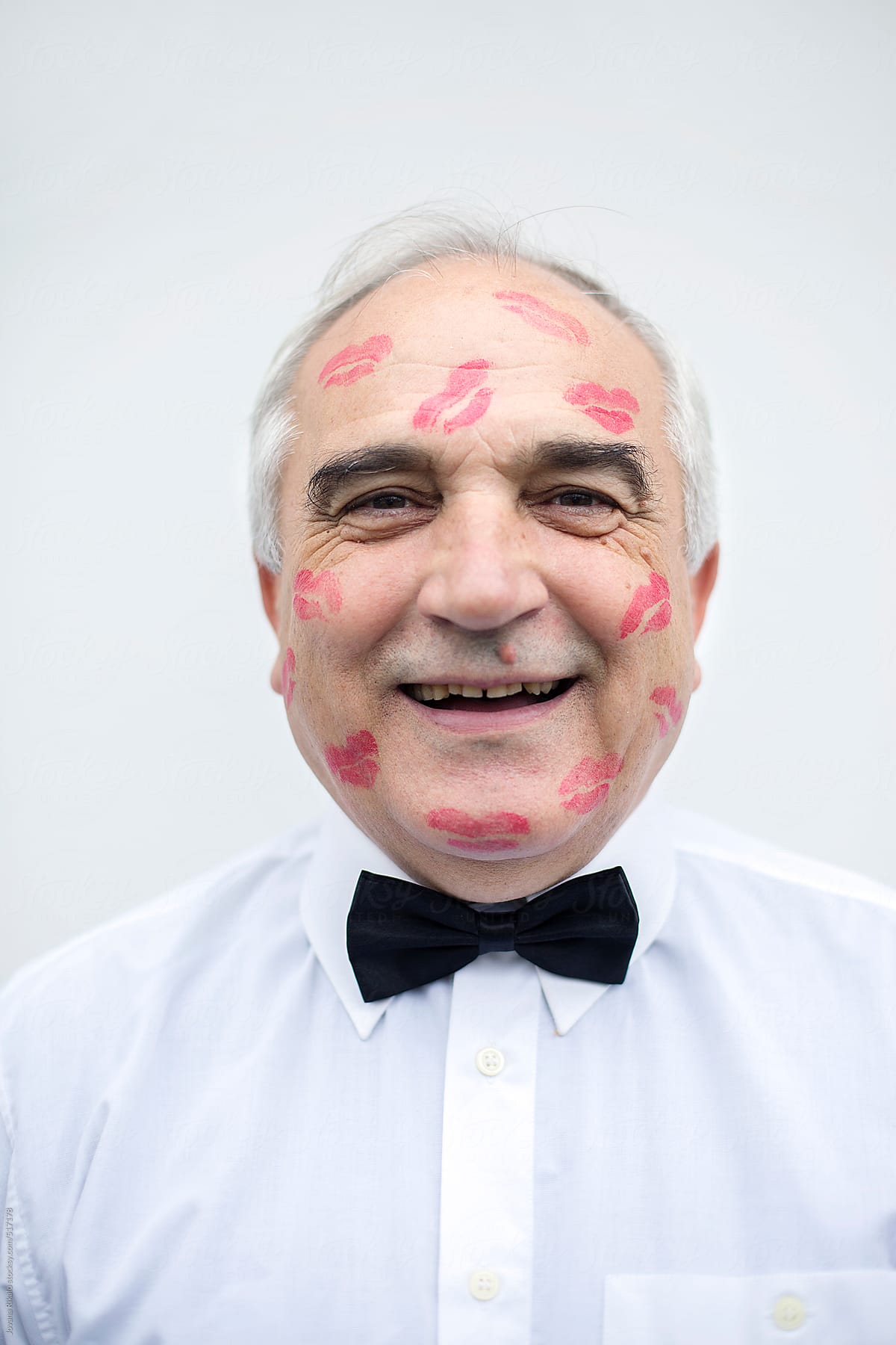 Portrait of an old man with red lip print on his face