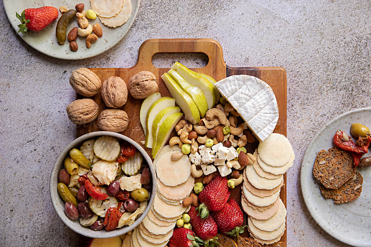 Overhead photo of a meat and cheese platter with fruit and nuts