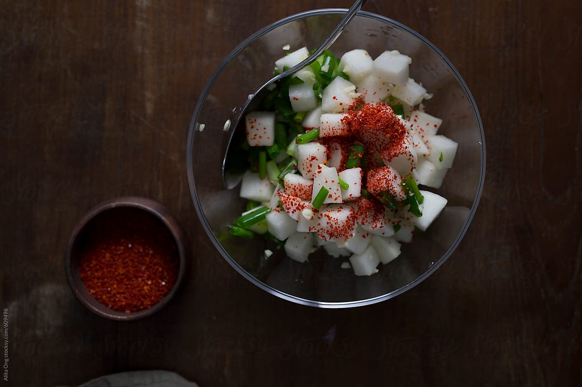 Daikon cubes in a bowl mixed with Korean chilli flakes