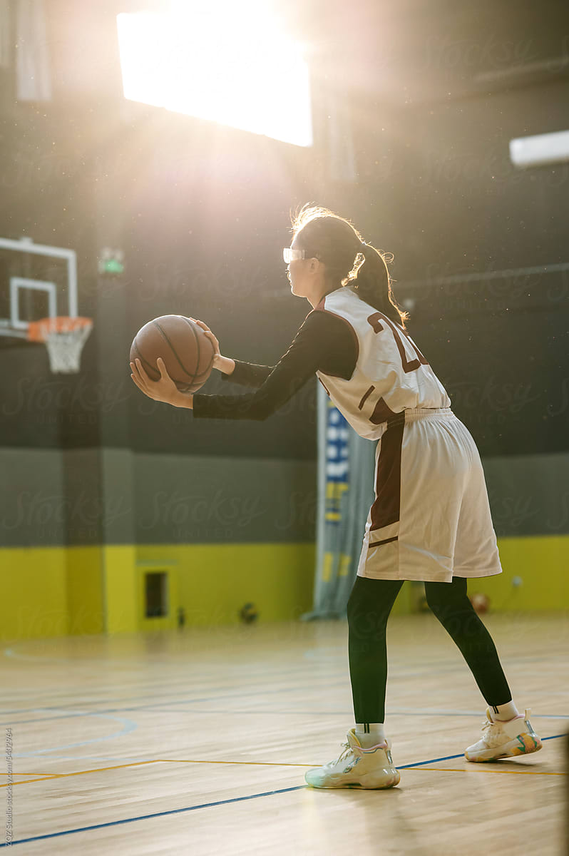 Teenage girl wearing basketball uniforms  and playing basketballs