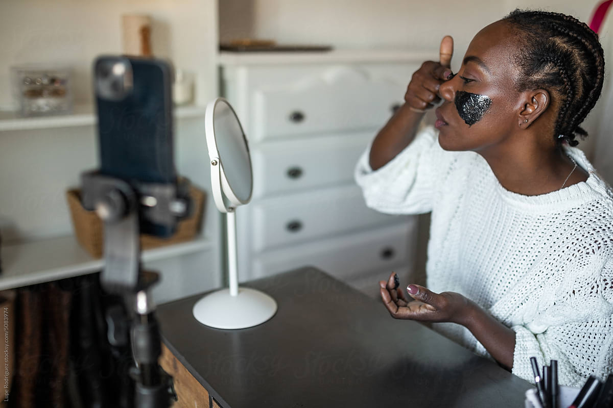 black woman blogger doing makeup at home