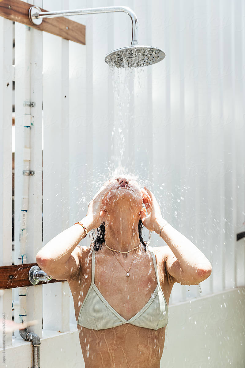 Woman washing her face at outdoor shower