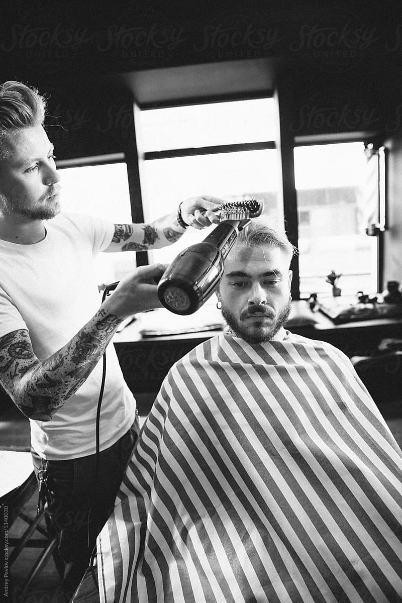 black and white of barber blowing client\'s hair