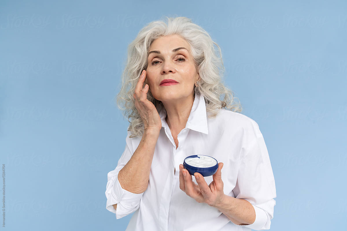 Senior Woman With Silver Hair Using Cream
