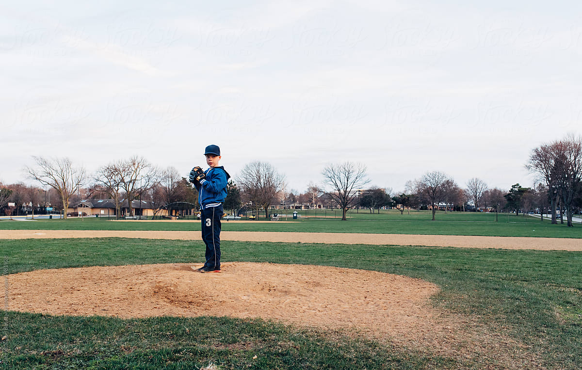 Young boy practicing pitching from a baseball field mound