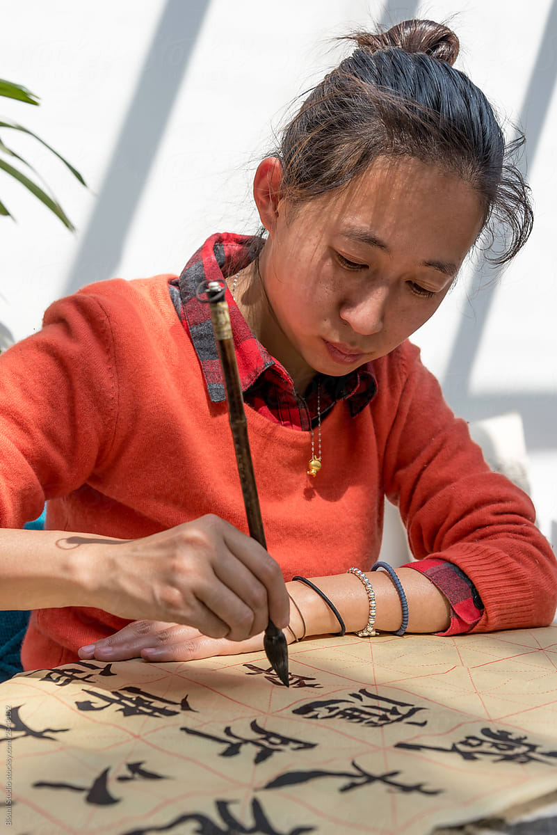 Woman painting chinese symbols