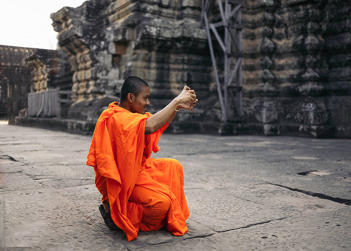 Buddhist monk taking photos in Angkor Wat temple