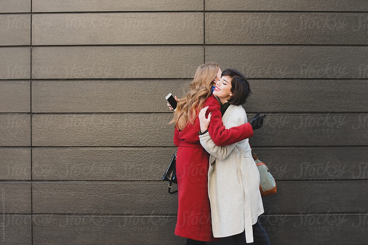 Young women hugging on the street