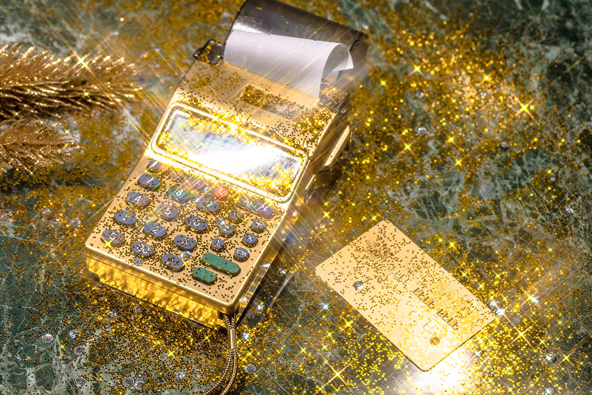 Gold card and pos terminal with bright festive sparkles and sparkles