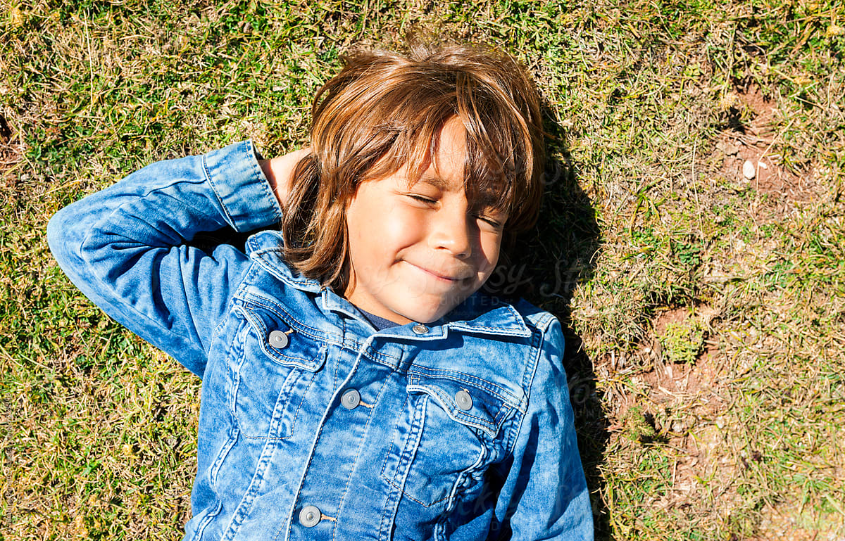 kid laying on the grass