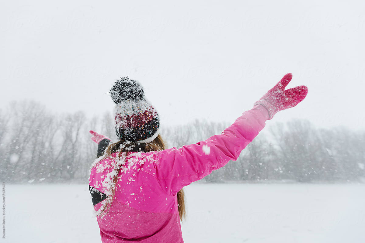 Anonymous woman outdoors enjoying snow in wintertime