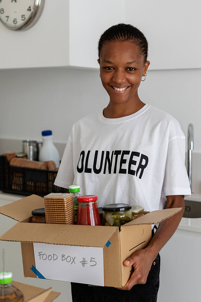 Young volunteer holding food box portrait