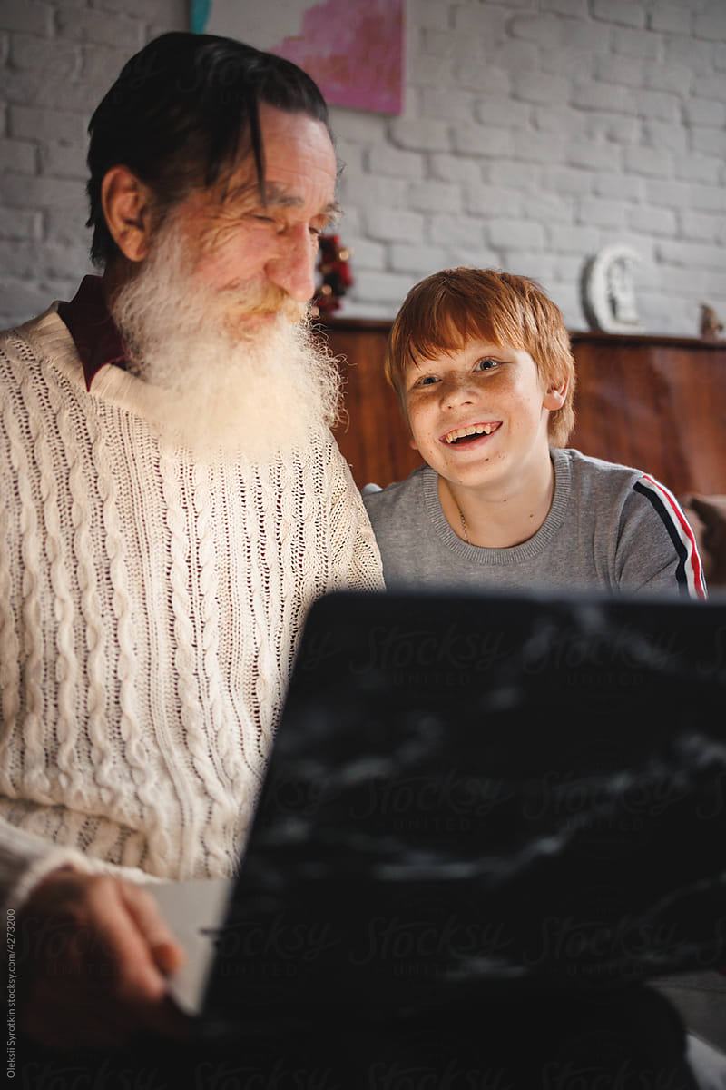 Grandpa studying use laptop which received on Christmas