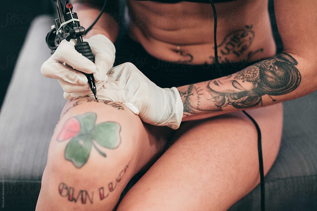 A woman tattooing itself