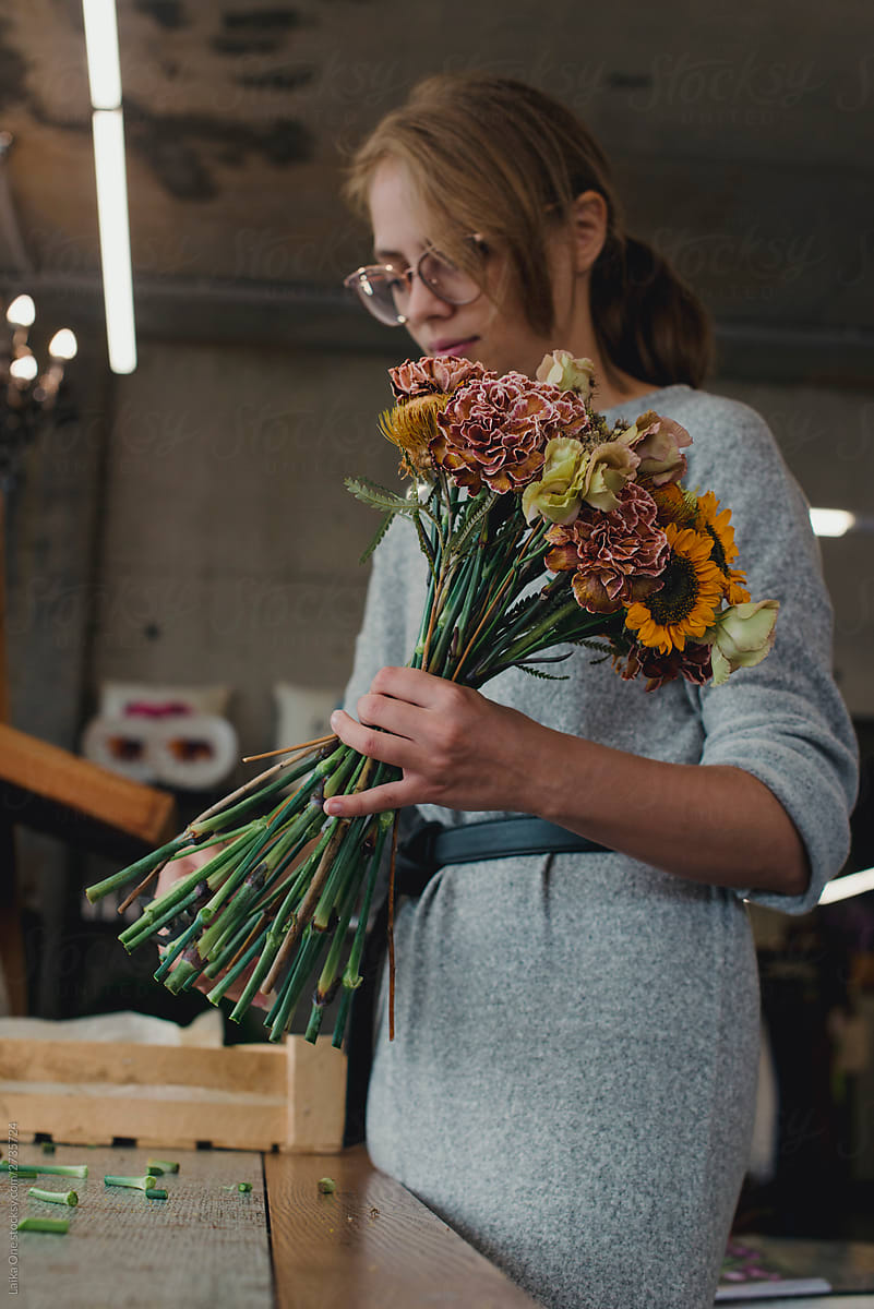 Female florist preparing bouquet of flower at his flower shop