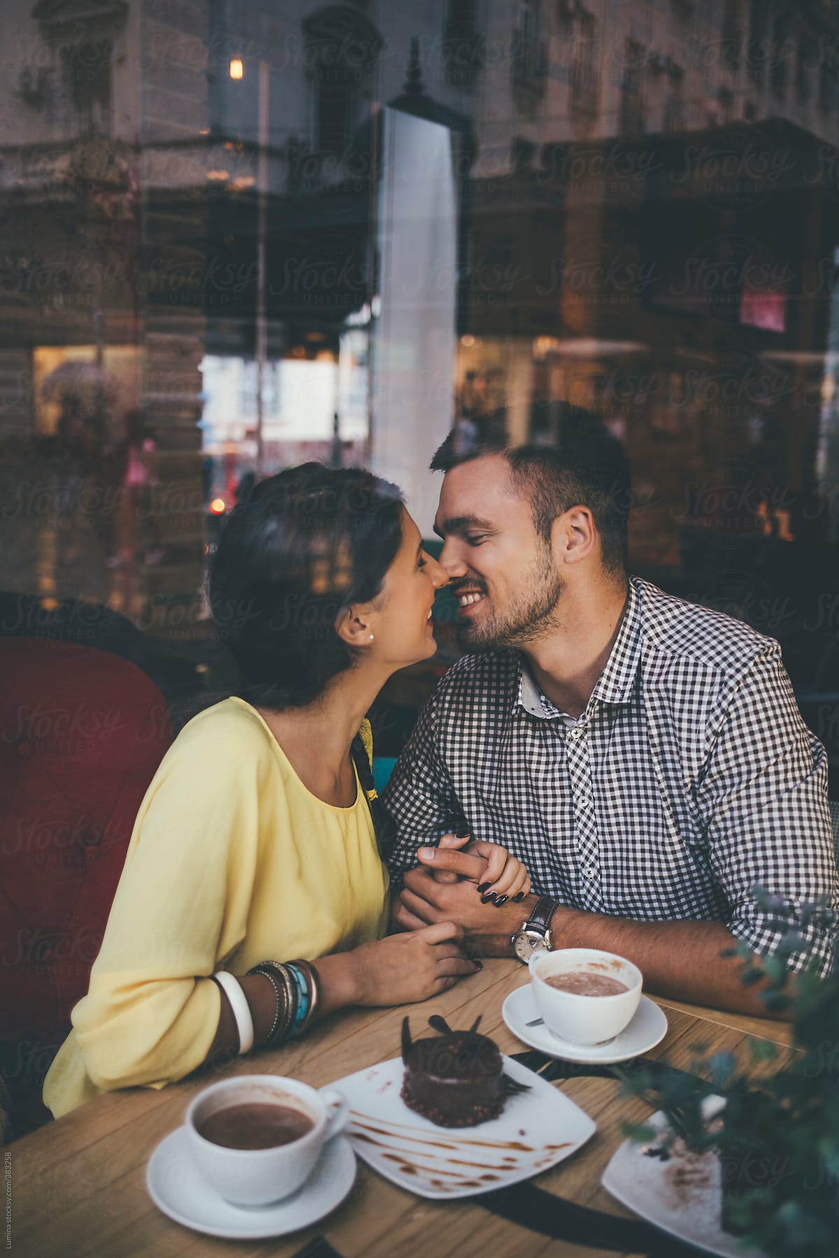 Caucasian Couple in Love Kissing at a Cafe