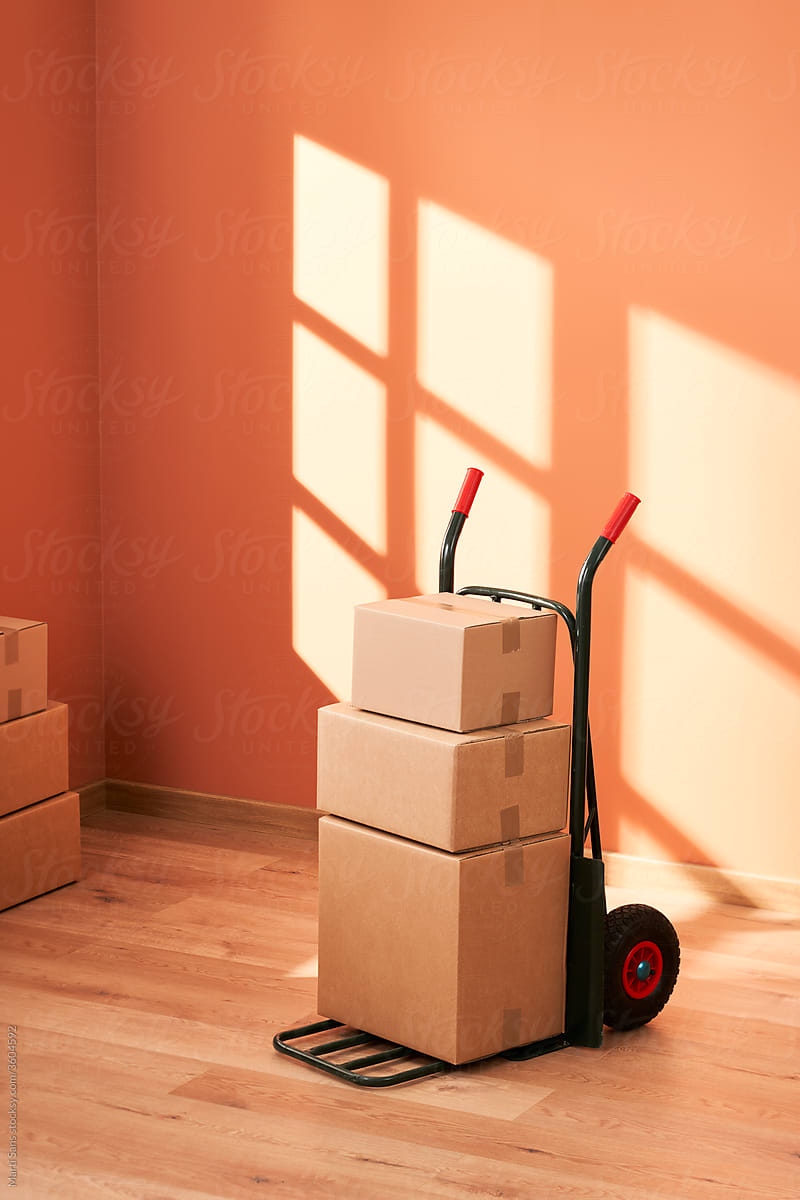 Cart with boxes in empty room