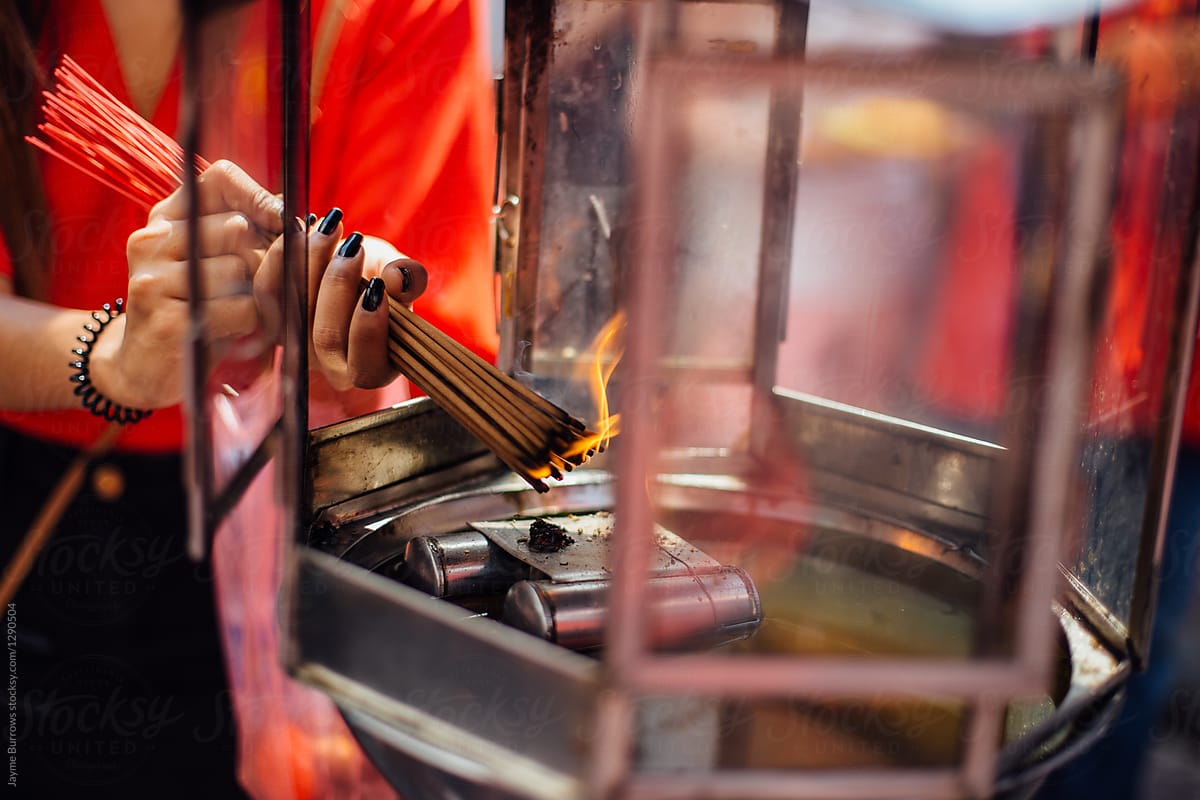Woman Celebrating Chinese New Year by Burning Incense at a Buddh