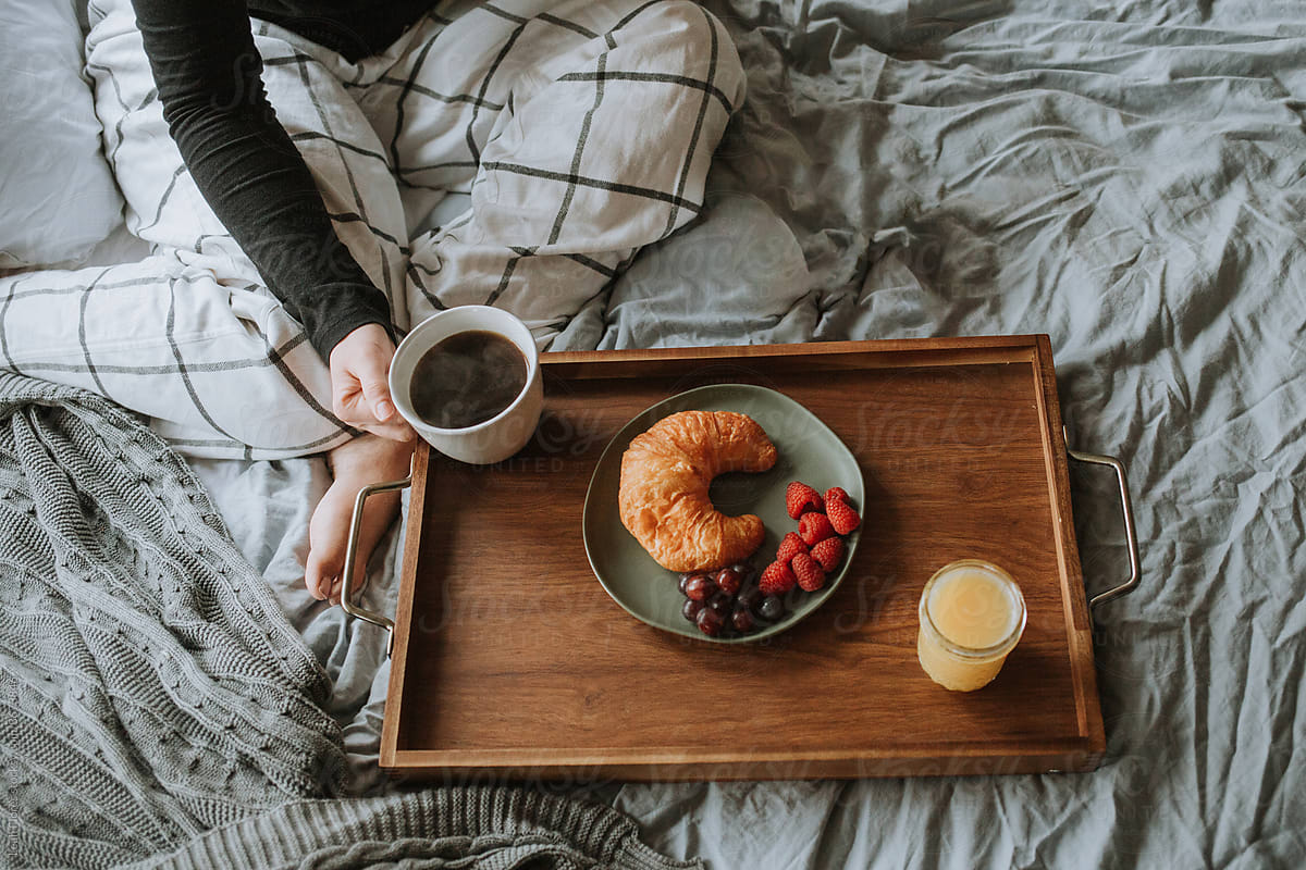 Cozy Bed with Coffee, Pastry, and Juice on Tray
