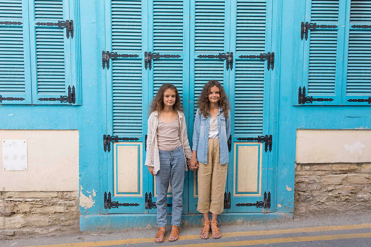 two twin sisters on the background of doors