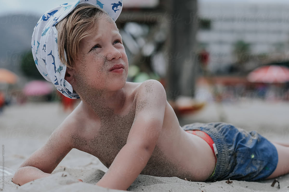 Young blond boy sunbathing at the beach