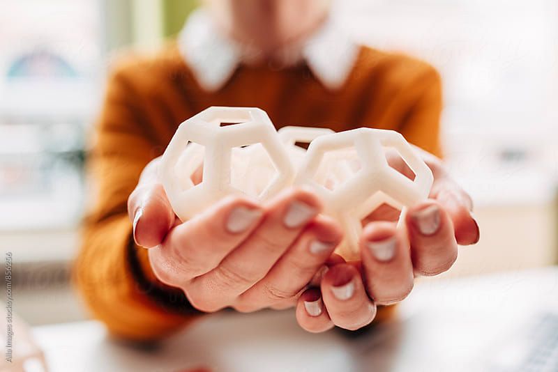 Engineer holding and inspecting 3d printed hexagon design samples