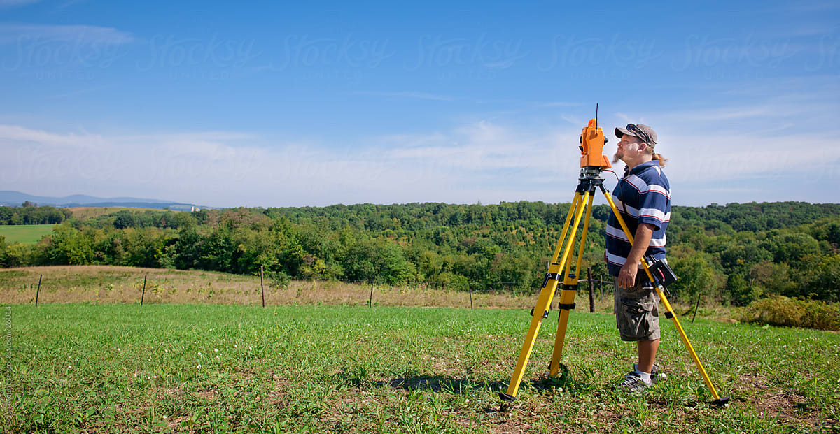 Land Surveyor Instrument Operator Working in Field