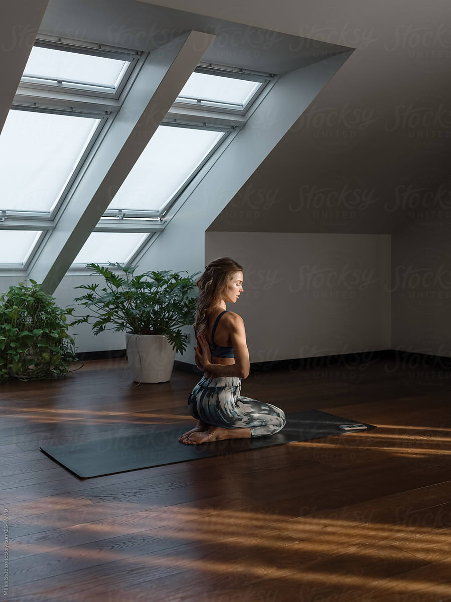 Young woman in asana meditating on mat
