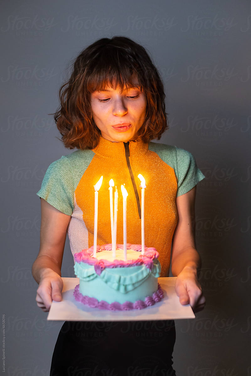 Party girl blowing out candles on a cake at her birthday celebration