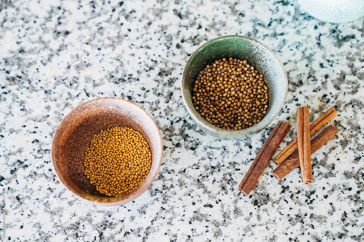 Spices  in small bowls with cinnamon sticks on counter