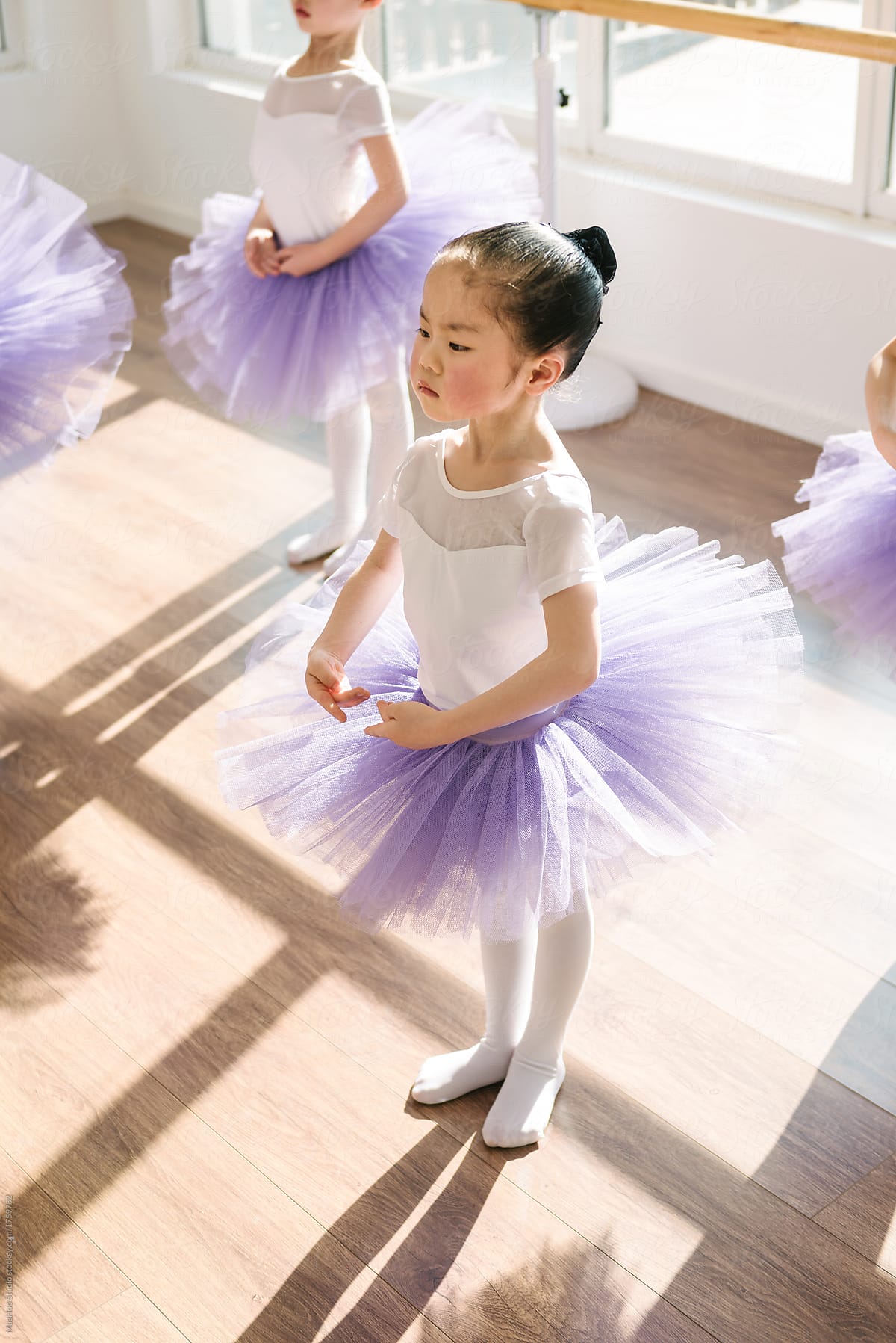 Children practicing ballet poses in ballet studio