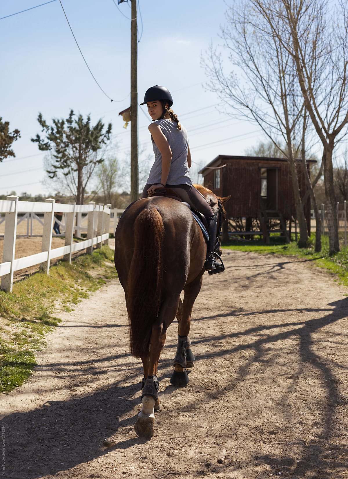 Young woman riding horse on farmland