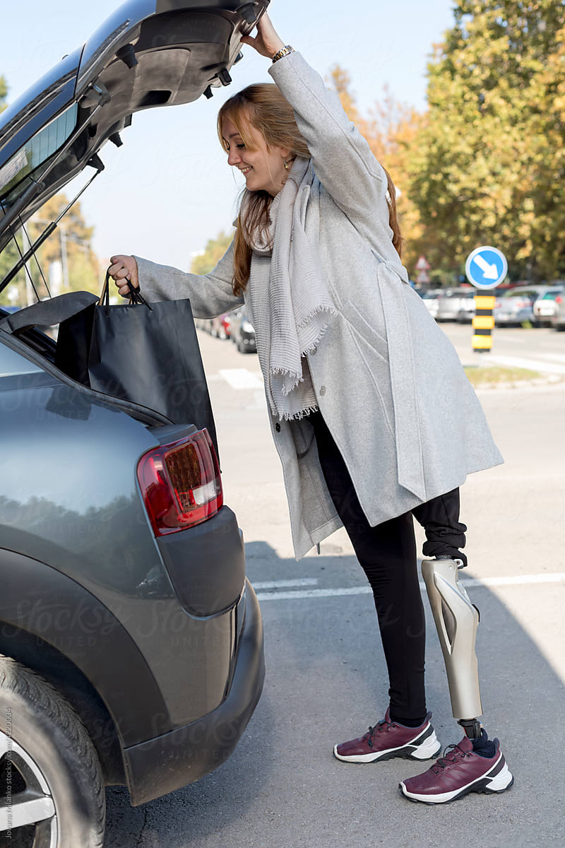 Woman putting shopping bags in the trunk