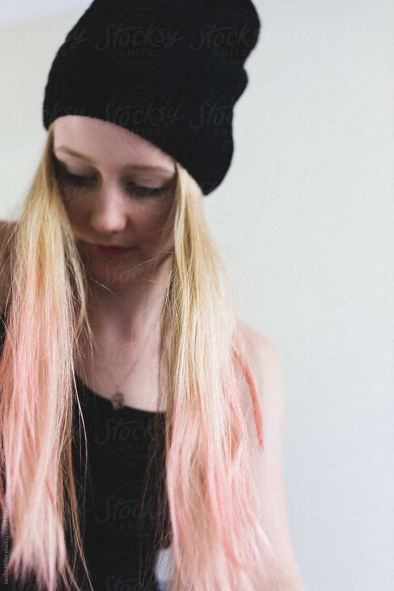 Teen girl with blonde and pink hair. Selective focus is on her hair not her face.