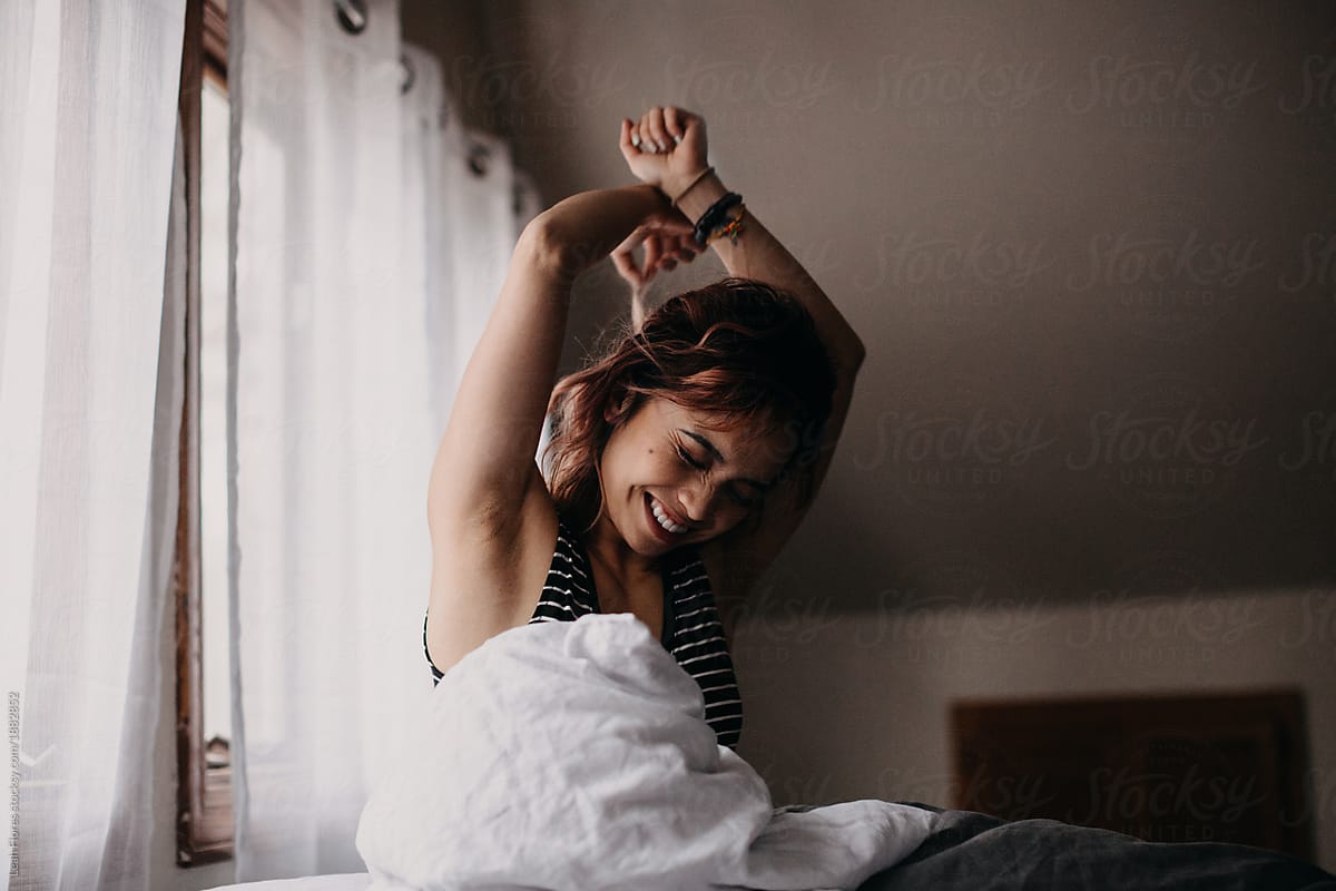 Woman Waking Up And Stretching In Morning By Stocksy Contributor