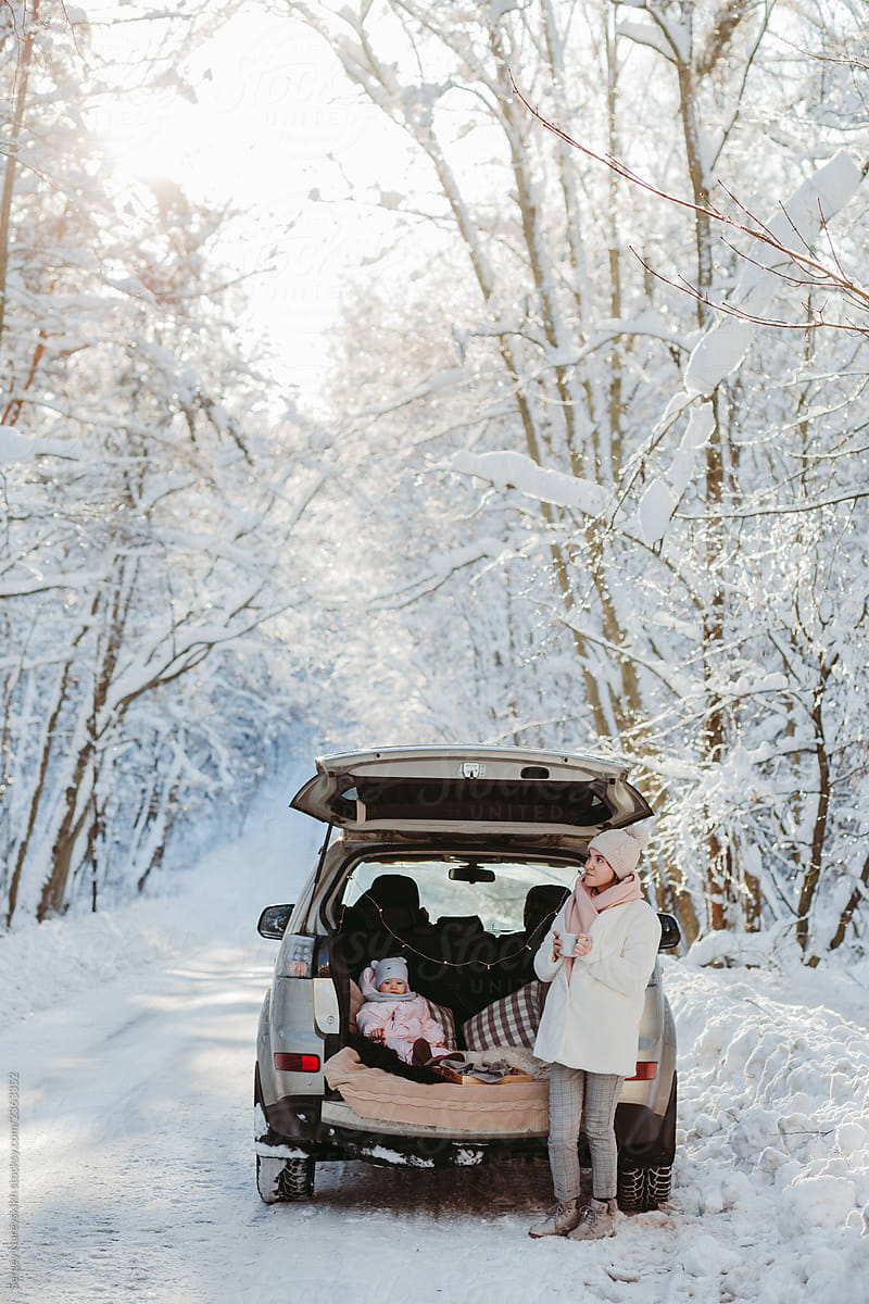 Mother and baby in car trunk in winter forest