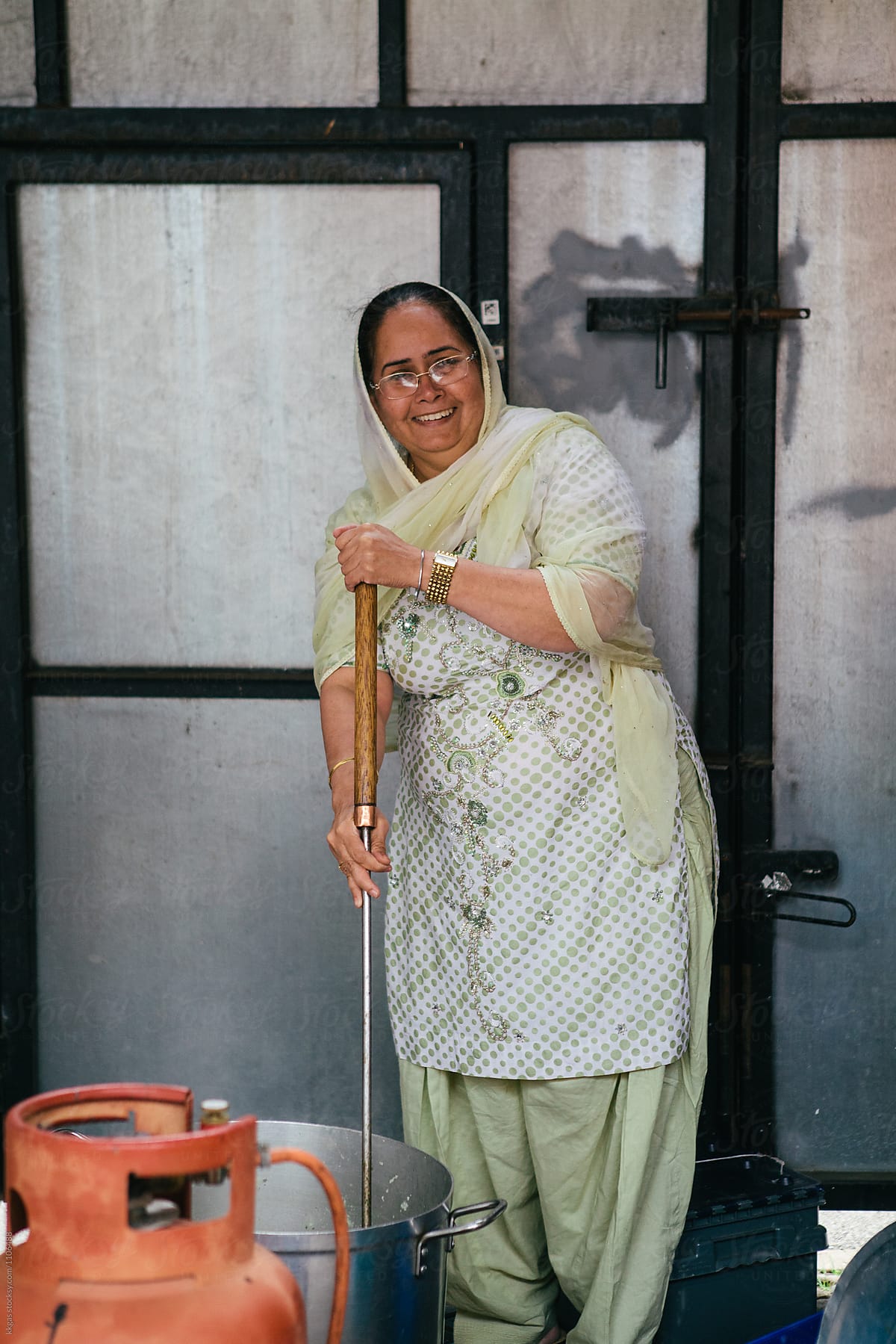 Indian woman cooking a large quantity of food