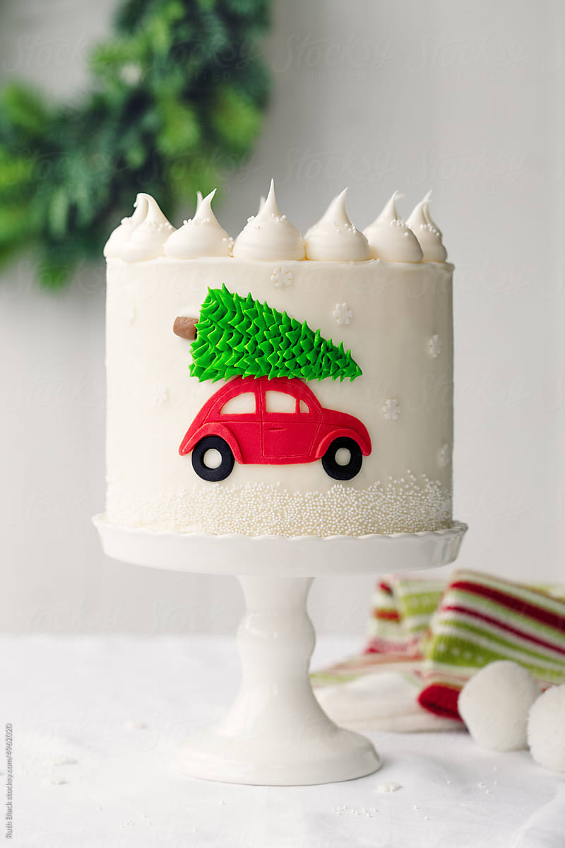 Festive Christmas cake with car carrying a Christmas tree
