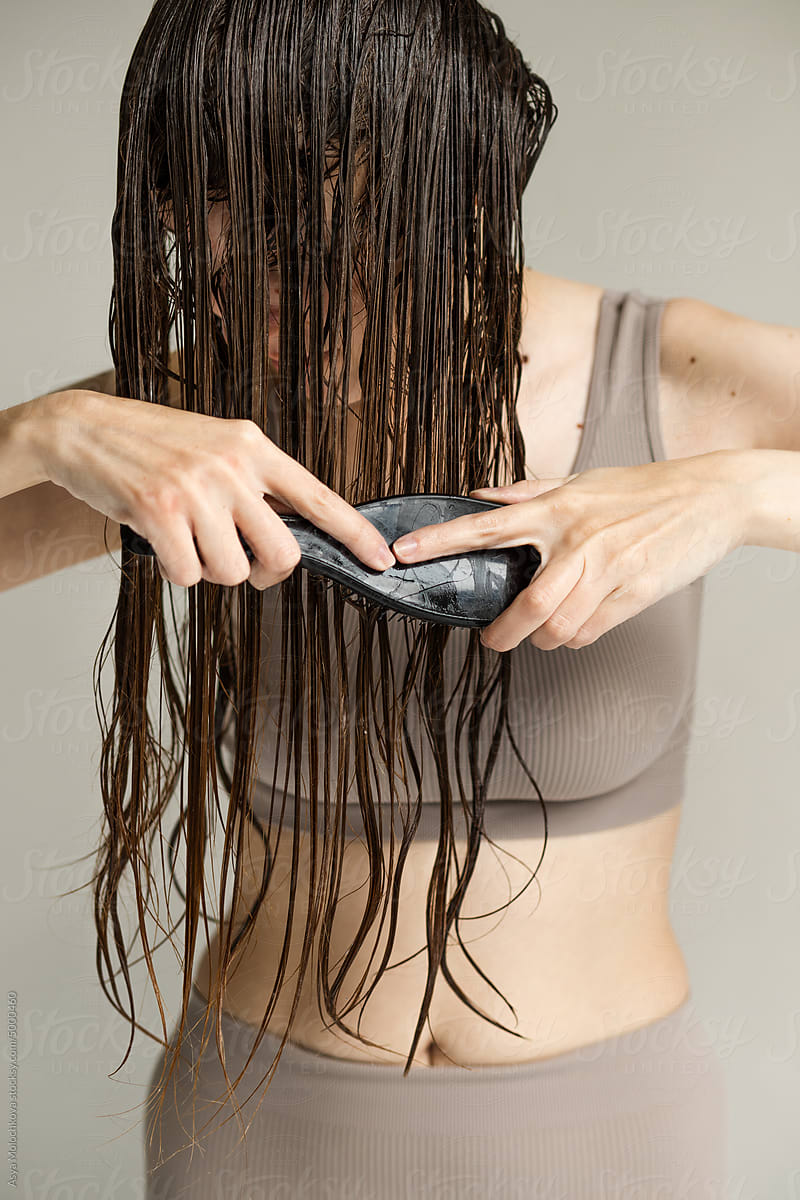 Real woman combing her wet hair