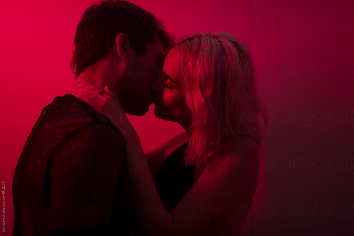 Kissing couple enjoying intimate moment during party