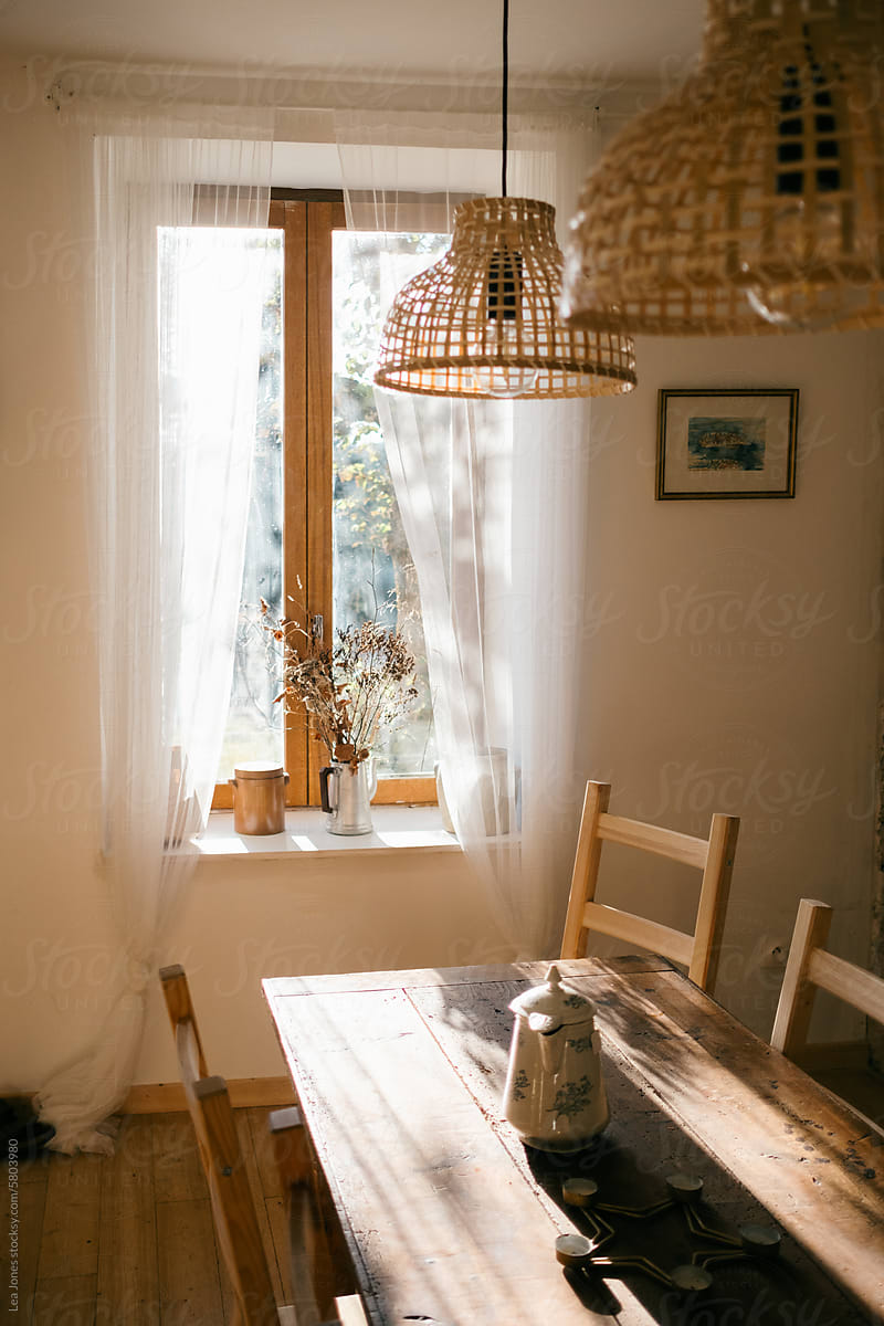 table and French windows with morning light and dried bouquet